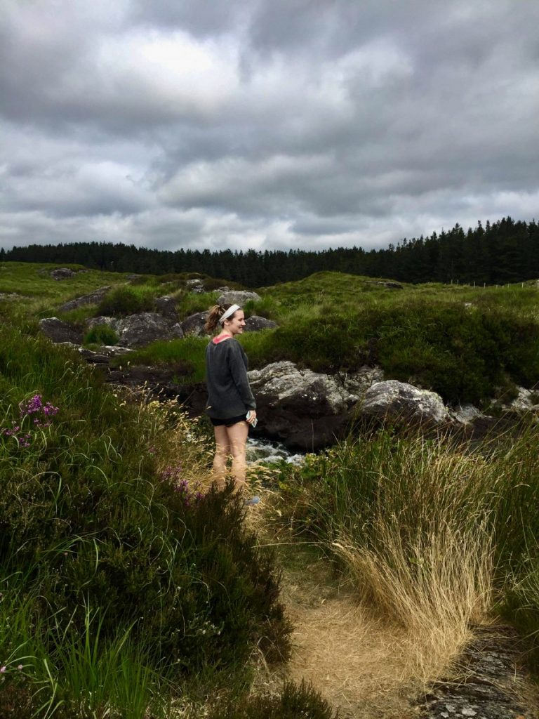 Woman stands in field in Connemara