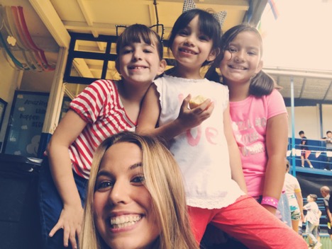 Study abroad student Lauren smiles with a few of her young students in Costa Rica