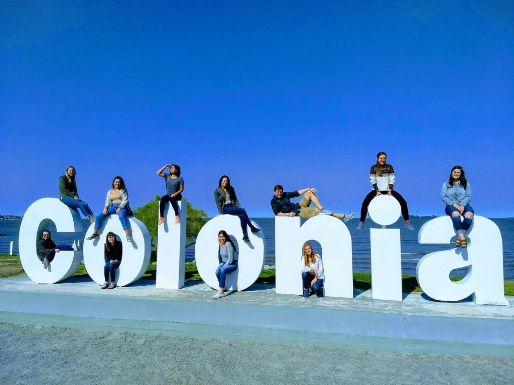 Students pose on Colonia sign in Colonia, Uruguay