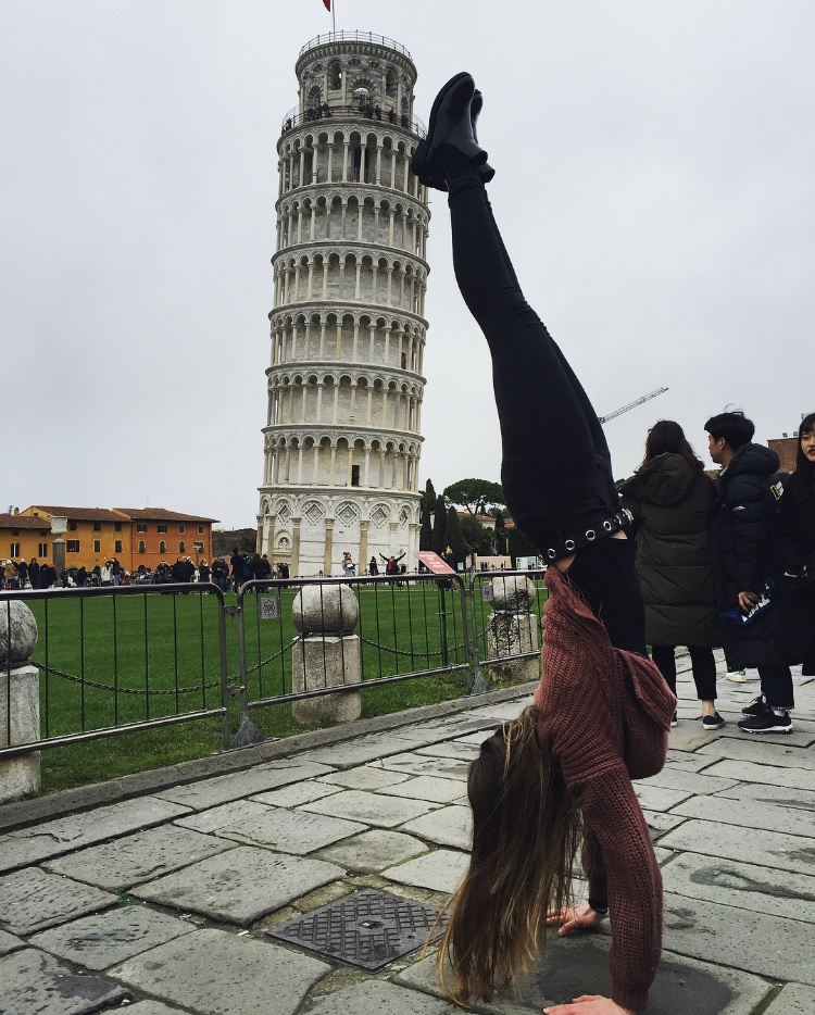 Global Leader Bella Martin does a handstand while on travel trip to Pisa