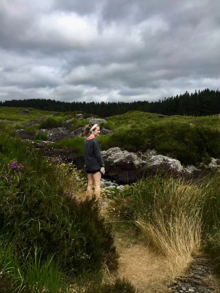Woman stands in field in Connemara