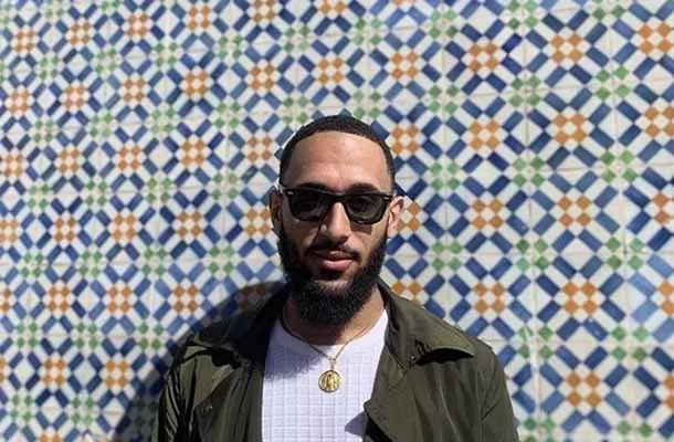 Student in front of geometric tiled wall