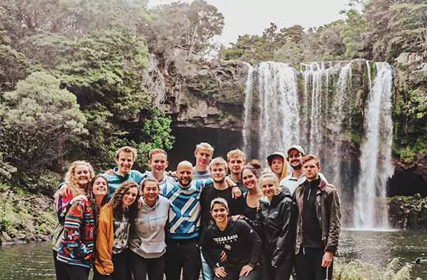 Student group posing in front of waterfall