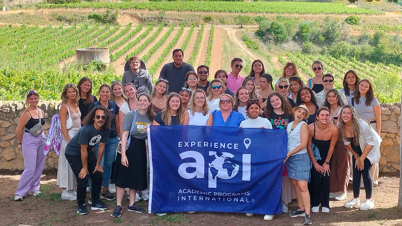 Barcelona-Spain-SU2024-API-Flag-Students-UCF-group-photo-with-flag,-farm-fields,-diverse-group_1280x720 API students in Barcelona